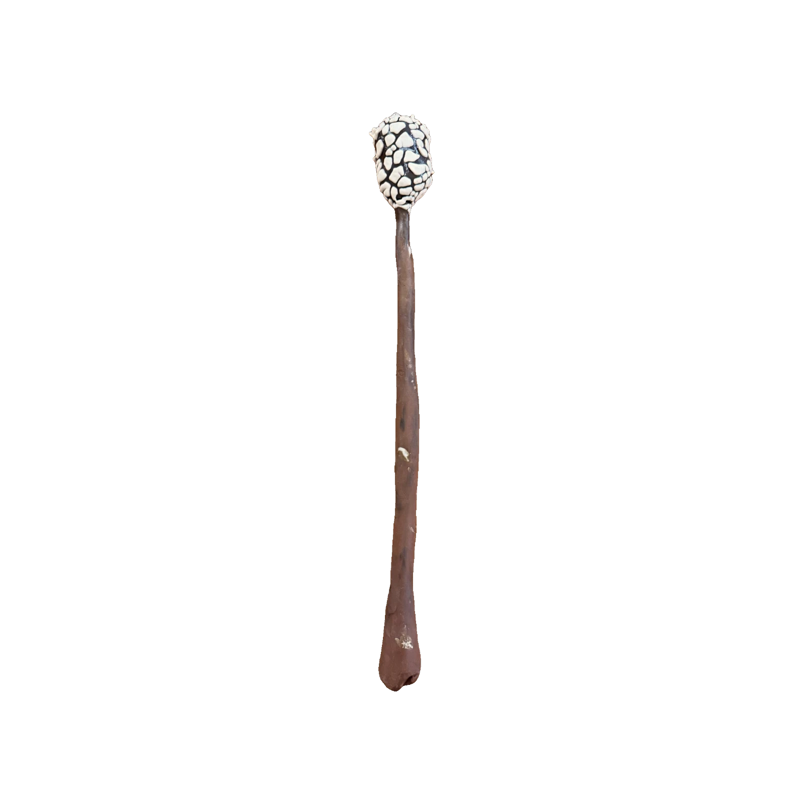 Ceramic sculpture of a thin stick topped with a cracked black-and-white textured sphere, like a charred marshmallow