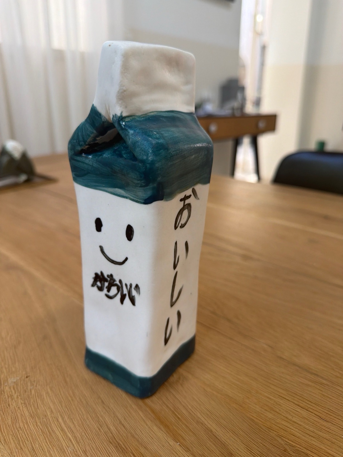Ceramic milk carton with a smiling face and Japanese writing
