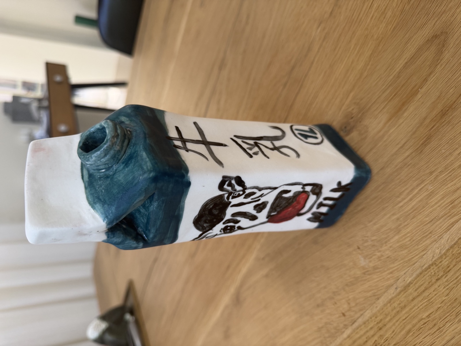 Ceramic milk carton painted with a dalmatian and the word MILK